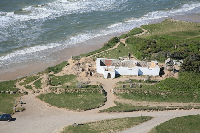 Luftfoto af Maarup Kirke meget tæt på havet.