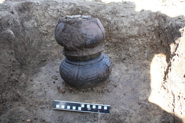 Foto af udgravningssituation. To urner sat oven på hinanden. Foto: Museum Odense.