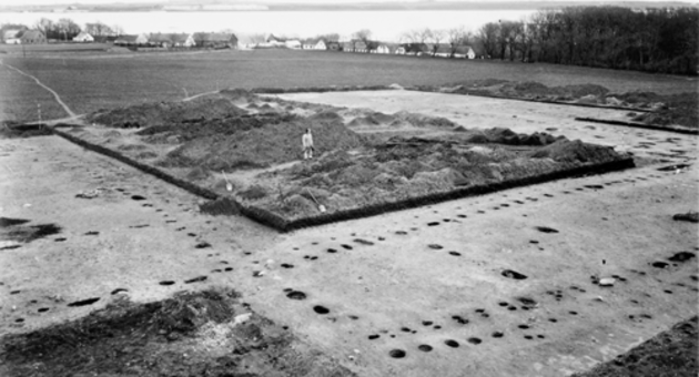 På foto ses en arkæolog stå midt mellem tre udgravede langhuse. Kun knap en fjerdedel af Aggersborg er blevet udgravet. Aggersborg blev udgravet mellem 1945 og 1952.