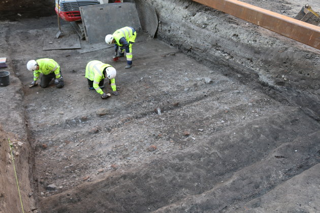 Foto fra udgravningen hvor Arkæologer fritlægger det yngste forløb af gaden, der løb langs byvolden. Hjulsporene ses tydeligt. Foto: Københavns Museum