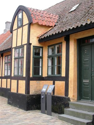 Karnaphuset is an old, yellow house with black half-timber