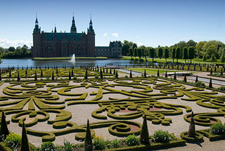 Foto af Frederiksborg Slot med barokhaven i forgrunden.