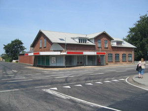 Foto af rødt mudstenshus med senere omdannet fasade