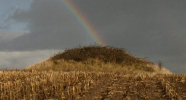 Foto af Hashøj på en gråvejsdag, hvor en regnbue lyser klart i baggrunden