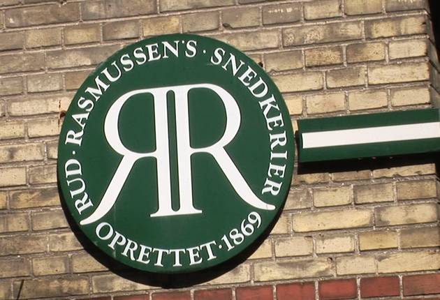Rud.Rasmussen Foto af de grønne og hvide logo på gule bygningen