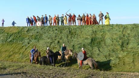 Rammedige Foto fra indvielsen, hvor krigere øverst på en bakke forsøger at bekæmpe ryttere ved foden af bakken.