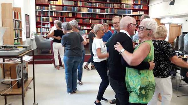 En gruppe ældre danser på biblioteket