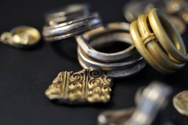 Skattefund fra germansk jernalder (400-500 e.Kr.). Foto Roskilde Museum Nærbillede aa et udvalg af sølv og guldgenstande fra pragtskatten fra Mannerup. Forrest ses dele af et spiralornamenteret smykke. Foto Roskilde Museum