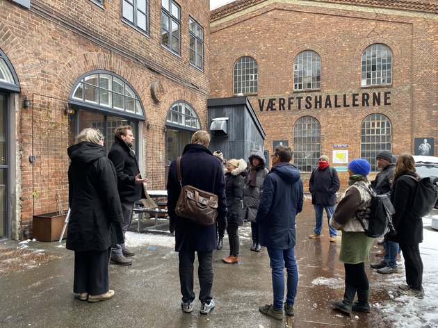 Mødedeltagerne står samlet foran Værftshallerne under byvandring