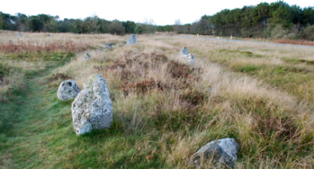 Stensætninger med graven under, ses i det høje græs