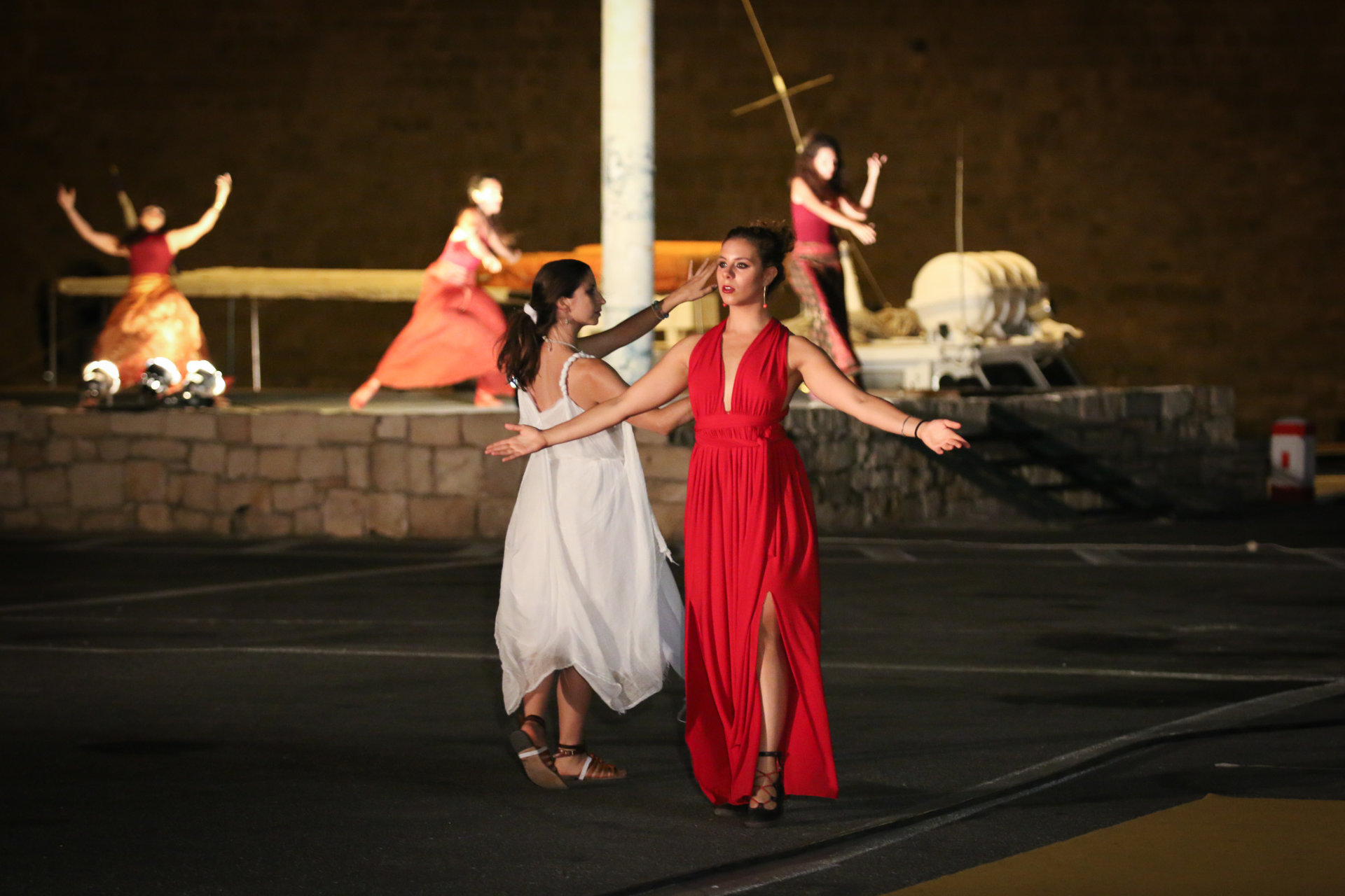 "Udendørs performance af Omma Studio Theatre (Grækenland) i Heraklion Port, 2016, Caravan Next/Odin Teatret. To kvinder danser." 