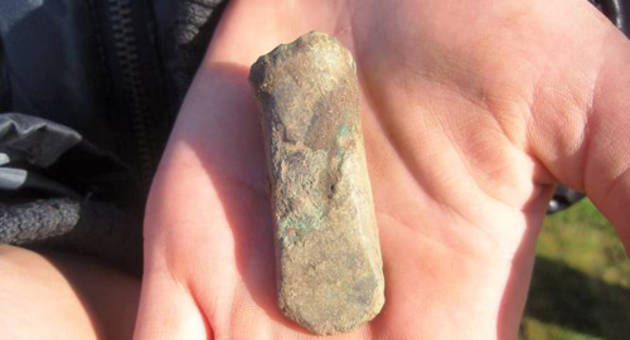 Mejsel af bronze – et lille spinkelt redskab fra yngre bronzealder (ca. 800-500 år f. Kr. fødsel). Foto Vikingeskibsmuseet Ladby Nærbillede af mejsel af bronze – et lille spinkelt redskab, der holdes af den heldige finder.