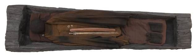 En mandsdragt fra 1365 f.kr. Kappe og hue var typiske dele af dragten. Foto: Nationalmuseet Foto af egekiste fra bronzealderen med bevaret dragt og udstyr