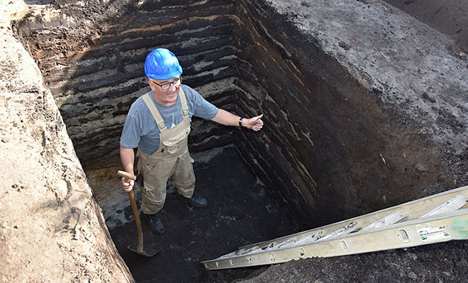 Opbygningen af Niels Bugges voldbanke med en ”kiksekage” af mørkebrune- og hvidstribede tørv ses tydeligt. Med blå hjelm ses museumsinspektør og arkæolog Jesper Hjermind. Foto: Lars Agersnap Larsen 2018. Opbygningen af Niels Bugges voldbanke med en ”kiksekage” af mørkebrune- og hvidstribede tørv ses tydeligt. Med blå hjelm ses museumsinspektør og arkæolog Jesper Hjermind. Foto: Lars Agersnap Larsen 2018.