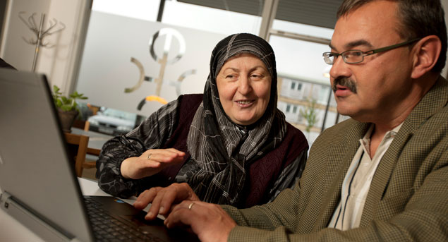 Mand og kvinde arbejder ved pc på bibliotekets IT-cafe i Tingbjerg.
