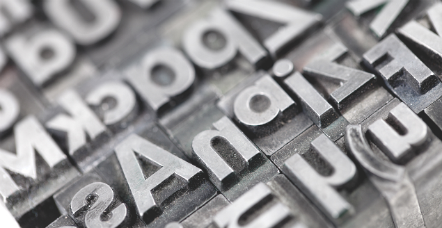 Foto af spejlvendte bogstaver i metal - gamle typograf-bogstaver til avistryk