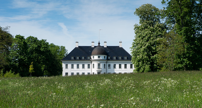Bernstorff Slot en sommerdag i grønne omgivelser.