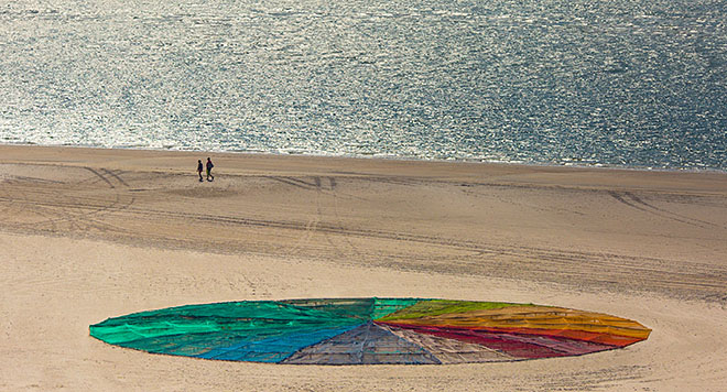 En cirkel i regnbuens farver på stranden